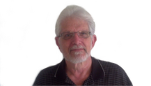 elderly_man_with_white_hair_white_beard_glasses_and_black_polo_shirt_happy_with_flexibility_and_hearing_aid_adjustments_to_personal_hearing_needs