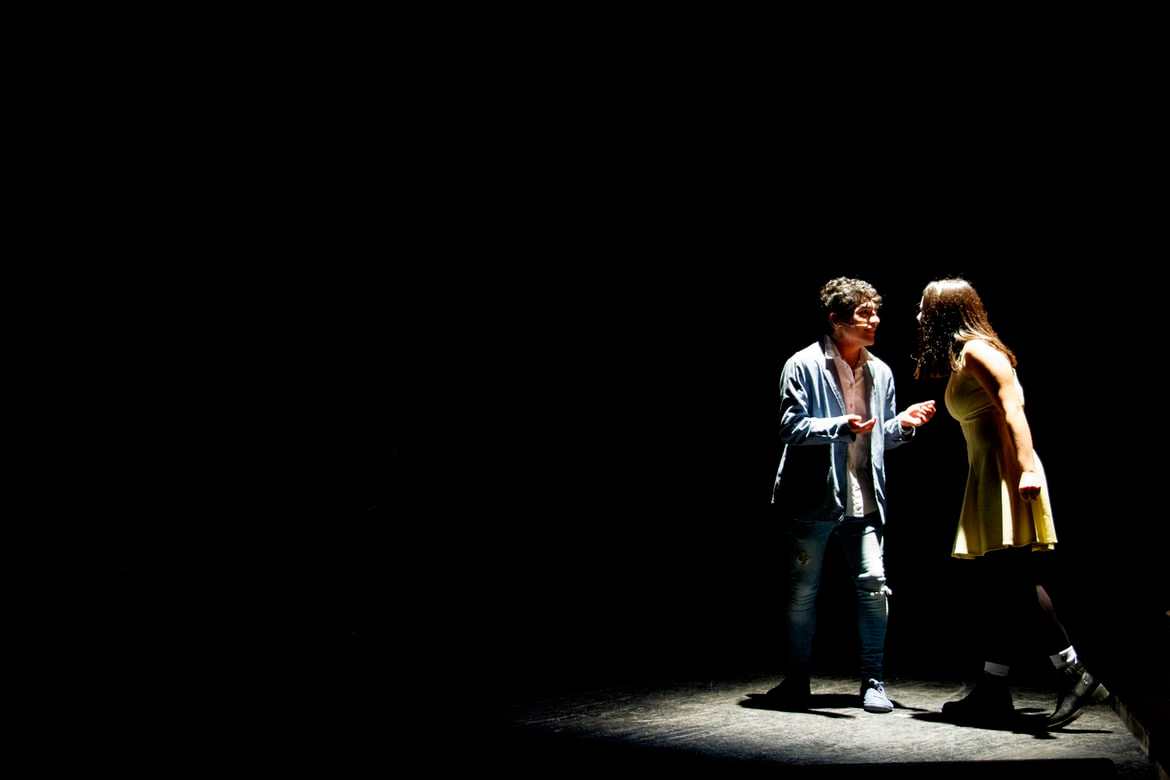 actors live on stage performing in spotlight