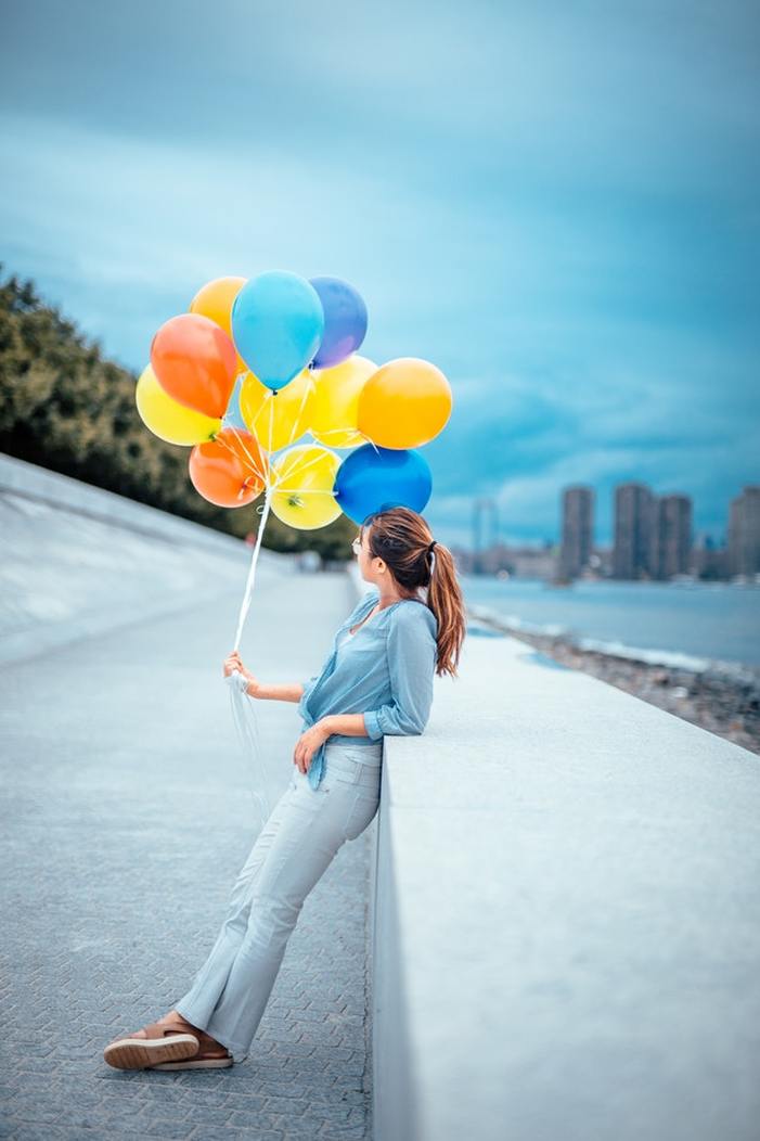 woman_with_balloons_feeling_happy_about_lyric_hearing_aids