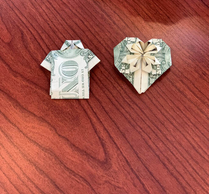 shirt and heart folded origami dollar bills on desk at hearing aid office