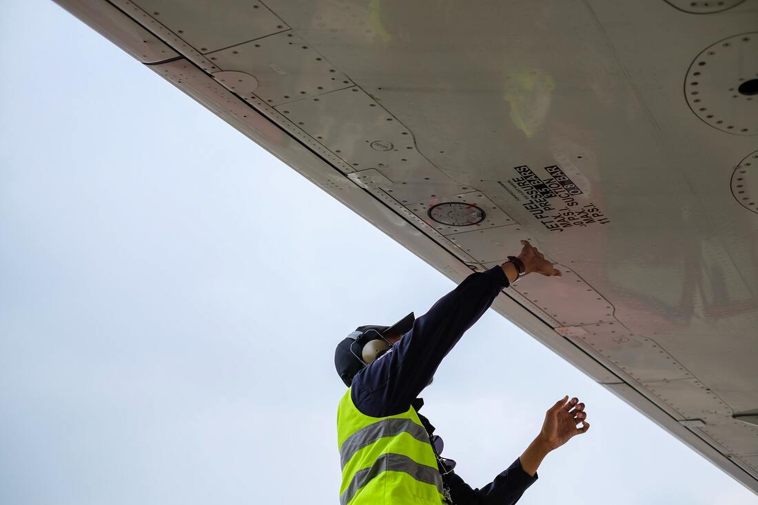 hearing_loss_airport_workers_under_plane_wing