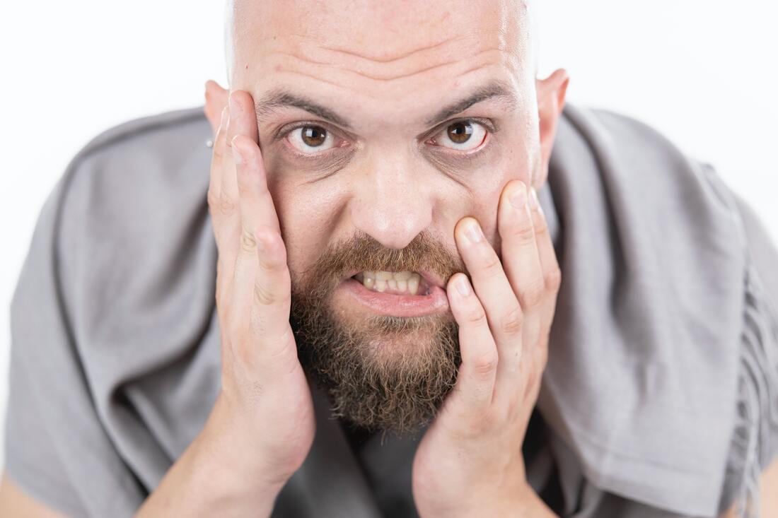 bald_brown_bearded_man_from_millersville_places_hands_on_face_when_annoyed_and_aggravated_by_noises