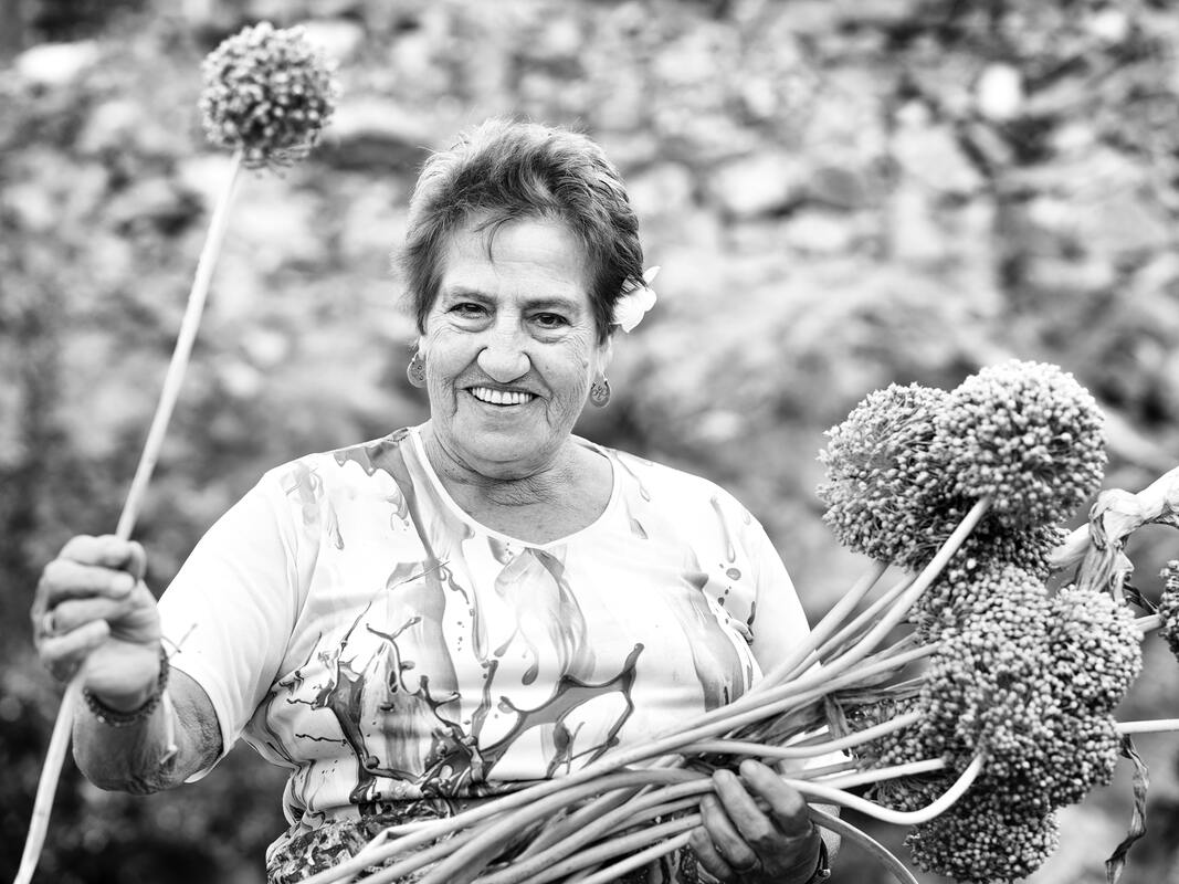 black and white photo of woman with hearing loss smiling and holding flowers