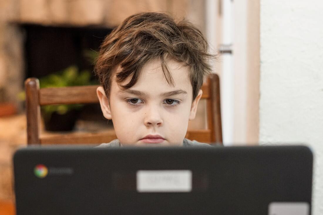 boy with hearing loss uses laptop for school