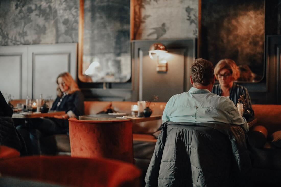 couples_with_hearing_loss_sit_and_comfortably_have_a_coversation_indoors_at_quiet_restaurant_with_grey_walls_and_warm_lighting_in_downtown_lititz