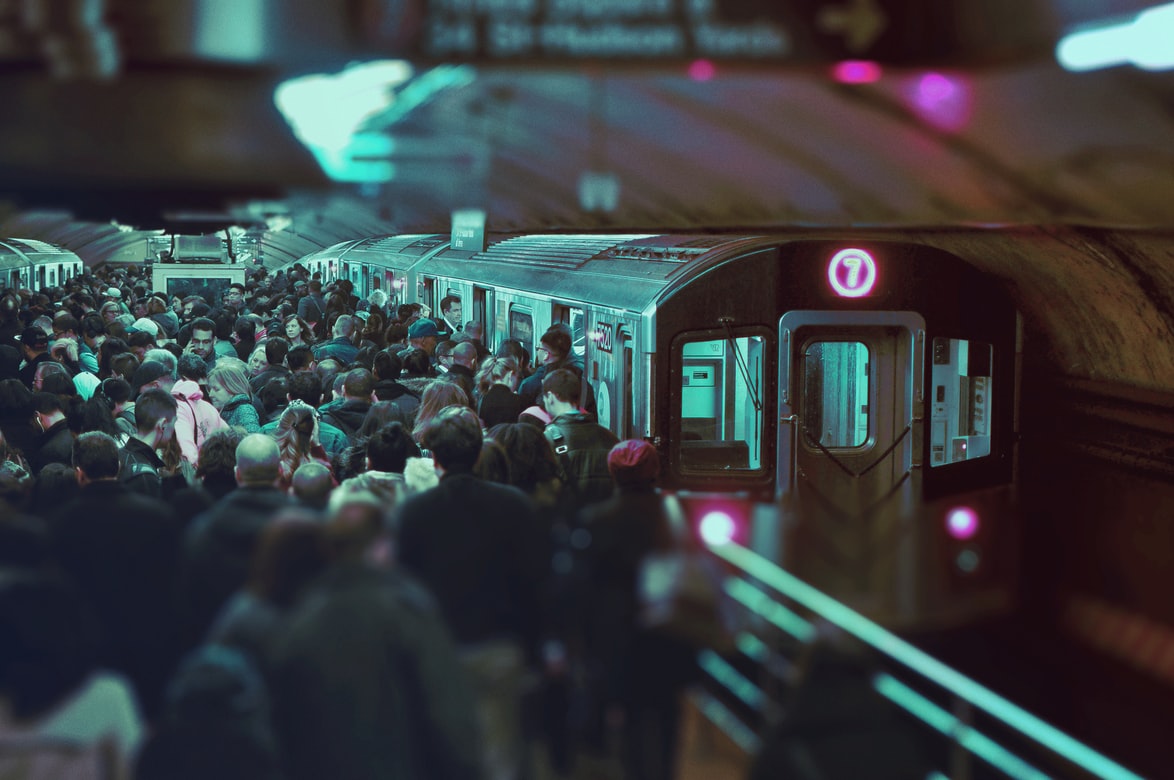 A crowded city subway platform with a train on the rails is too noisy for people with hearing problems.