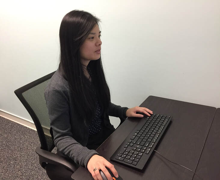 woman-sits-at-desk-and-uses-keyboard-to-work-on-hearing-aid-website
