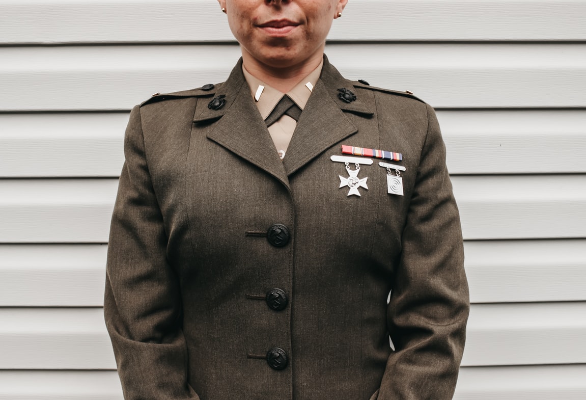 female_veteran_in_uniform_adorned_with_medals_has_hearing_loss