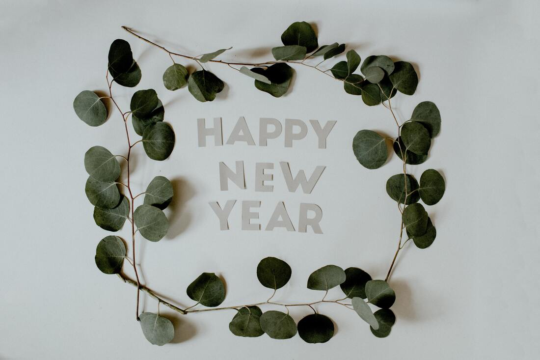 happy-new-year-in-grey-letters-with-green-leaves-on-small-branches-forming-a-square
