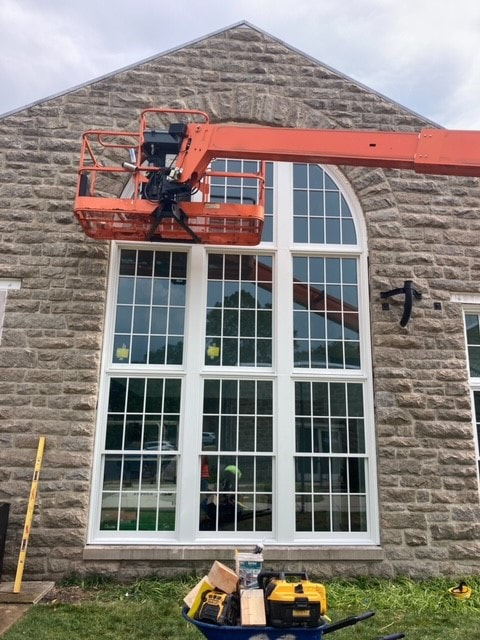 A hearing aid business gets a window installment with an orange cherry picker in Elizabethtown, PA.