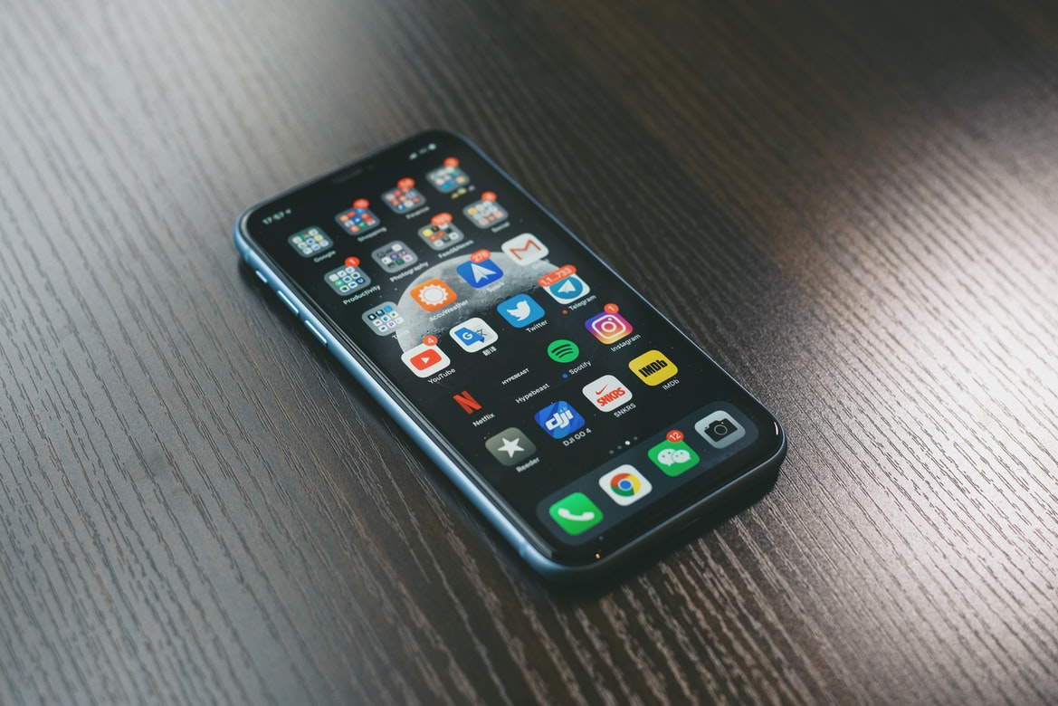 A black iPhone screen features apps paired with hearing aids.