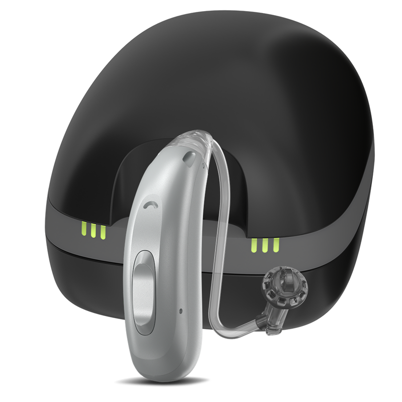 A rechargeable silver Rexton behind-the-ear hearing aid with a dome receiver and black charger.