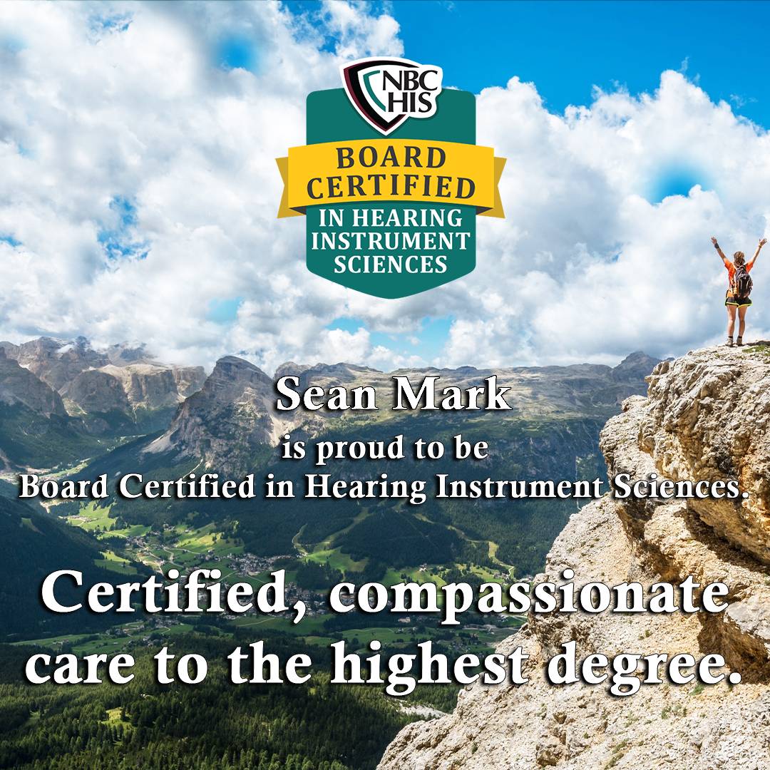 hiker_with_backpack_summits_mountain_stretches_hands_up_in_air_looking_over_mountains_and_lush_green_pastures_and_listening_to_nature_featuring_board_certififed_hearing_instrument_sciences_patch