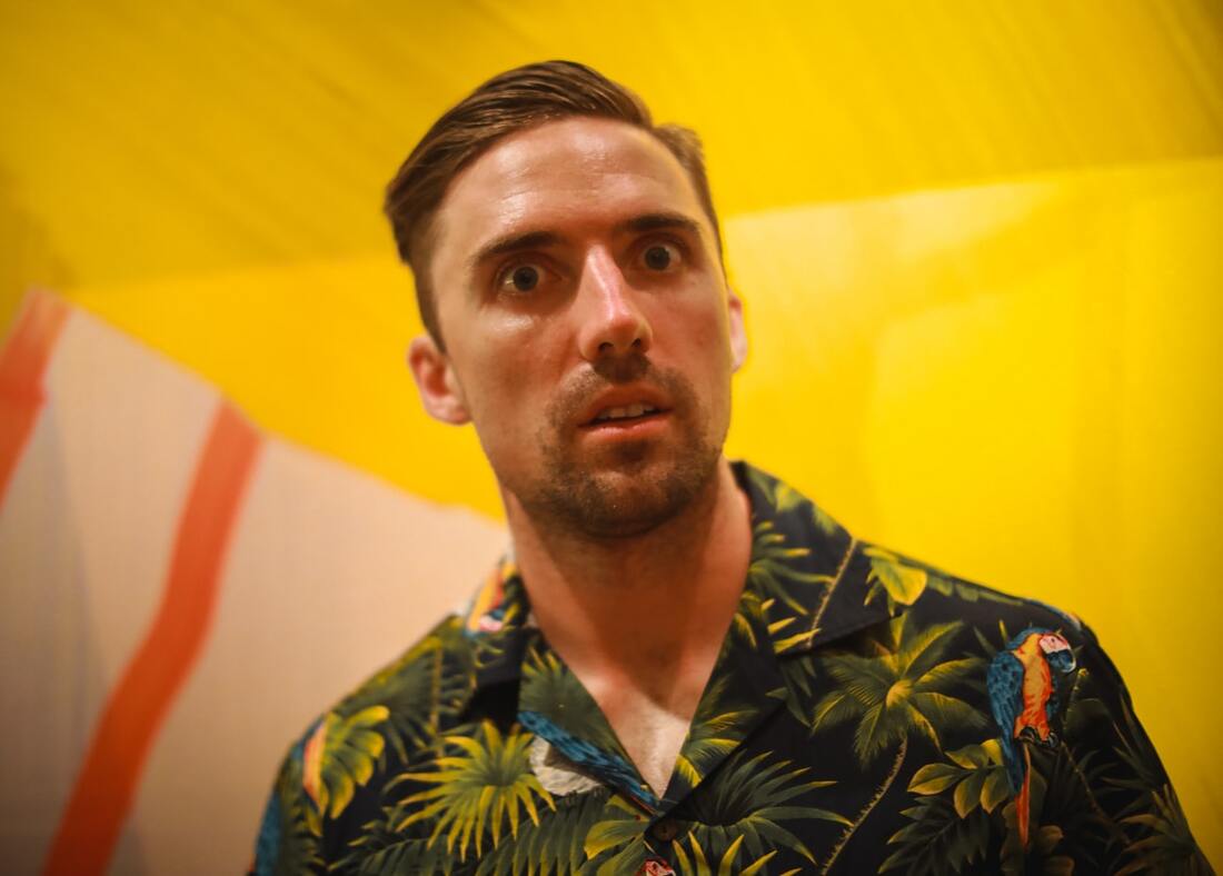 lancaster man with sudden hearing loss looks like deer in headlights while wearing hawaiian shirt in yellow background