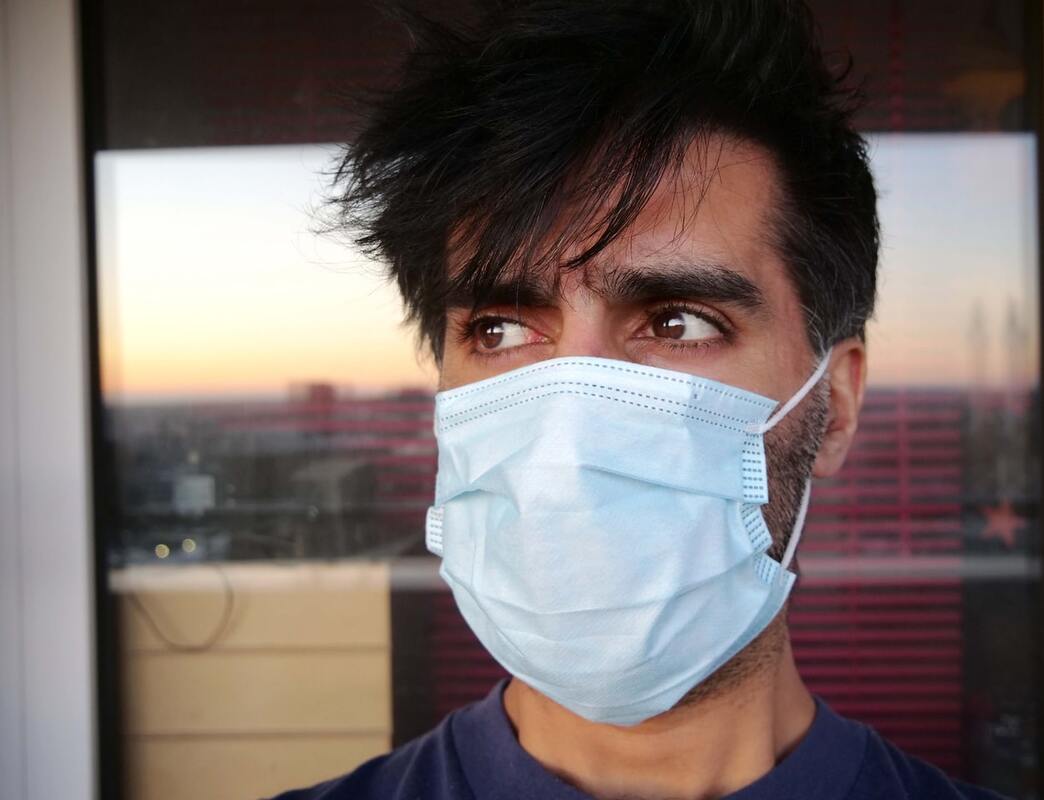 man with black hair and hearing loss wears light blue facemask
