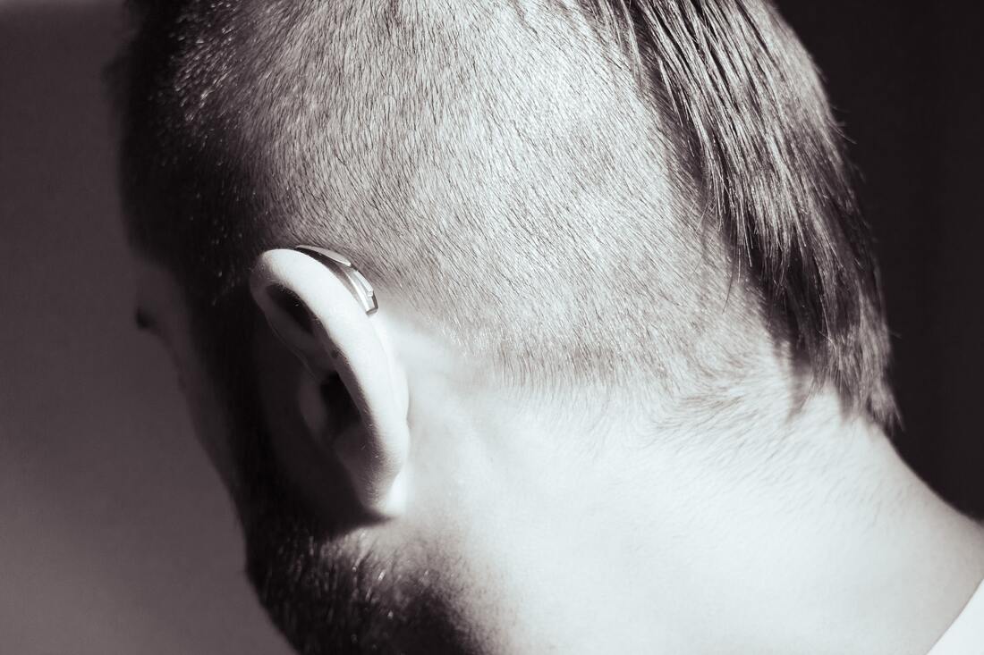 man with buzz cut and beard wears receiver in canal hearing aid