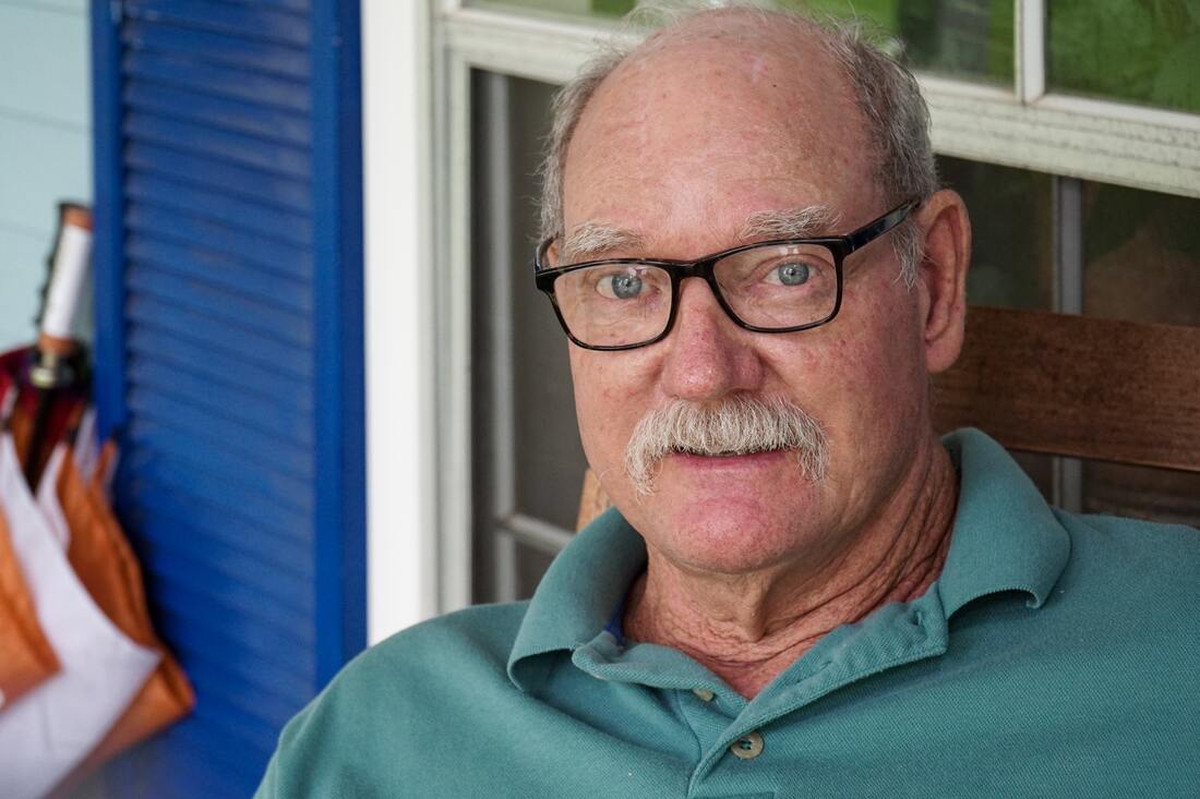 man with mustache wears blue green polo shirt black framed eyeglasses and has hearing loss in lancaster county