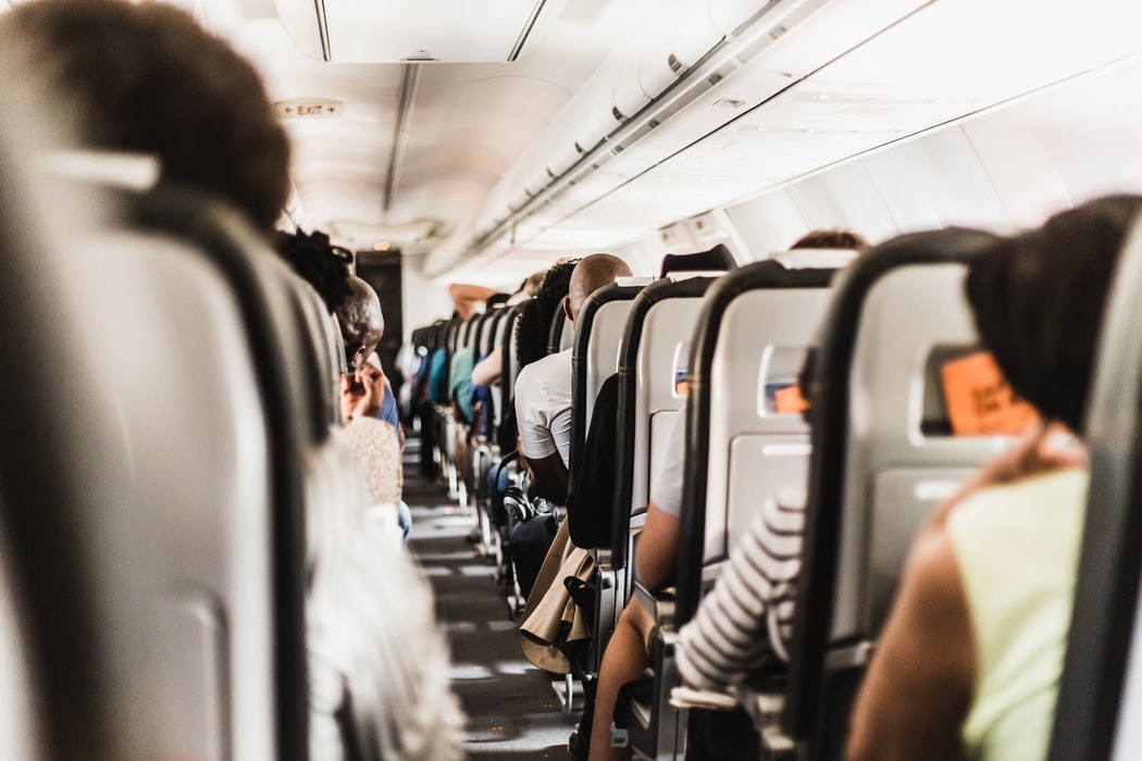 people sitting in an airplane experience pain in ears caused by air pressure