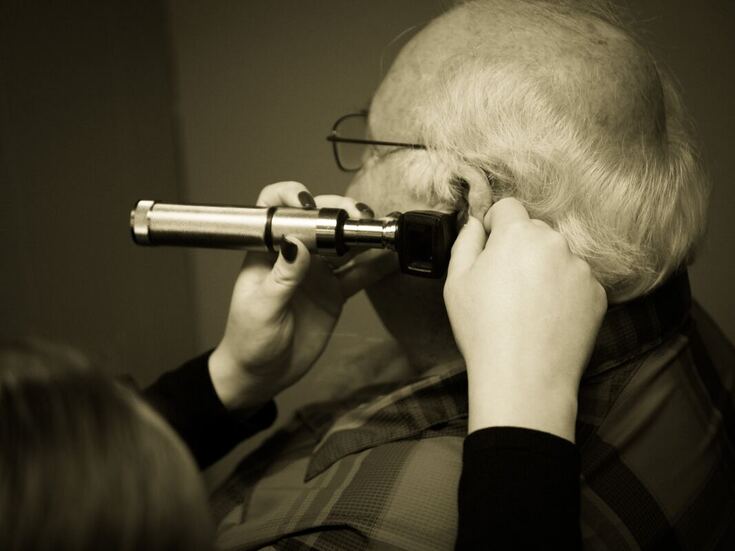 A man receives a hearing checkup with an otoscope for hearing aids in Lancaster, PA.