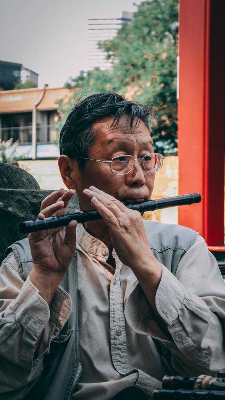 man_playing_the_flute_and_listening_to_his_music