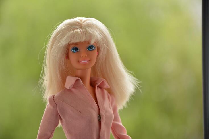 blonde barbie doll with pink shirt wears hearing aids