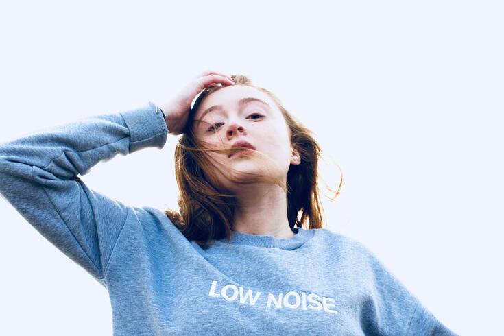 A girl with a light blue sweatshirt that reads 