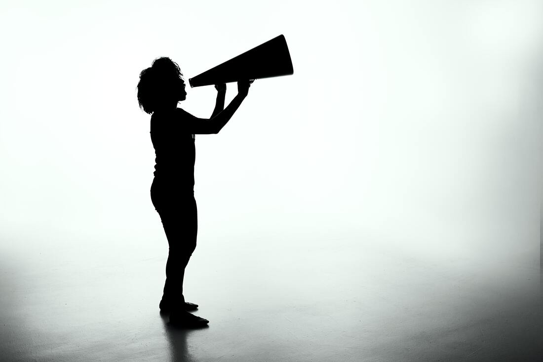 silhouette of woman holding old fashioned director large metal megaphone loud hailer
