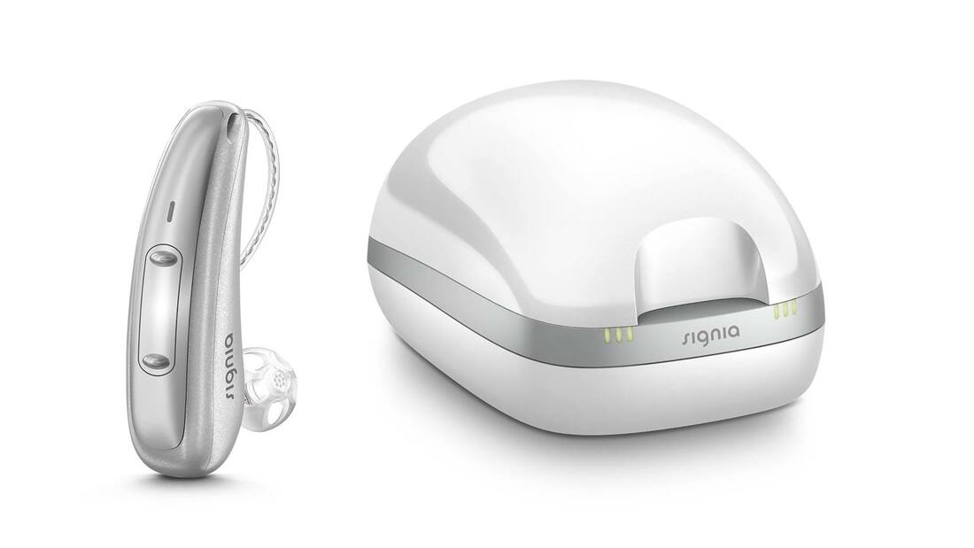 silver cros pure charge and go x hearing aid with dome and white hearing aid charger