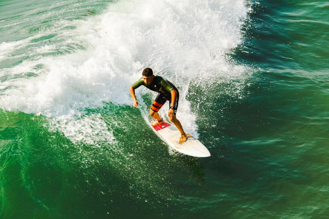 surfer on surfboard riding wave in green water experiences problems with ears