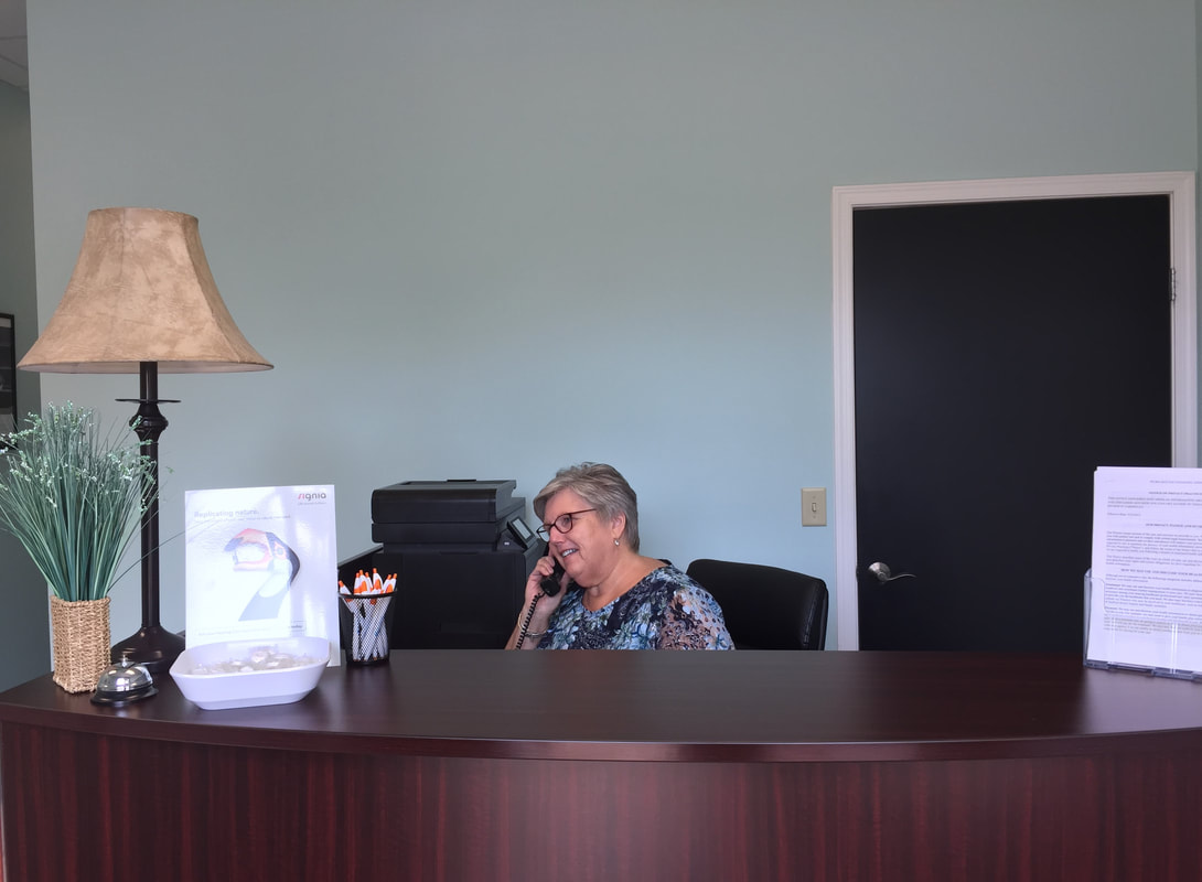woman at front desk schedules hearing test appointment for a local lancaster hearing aid company