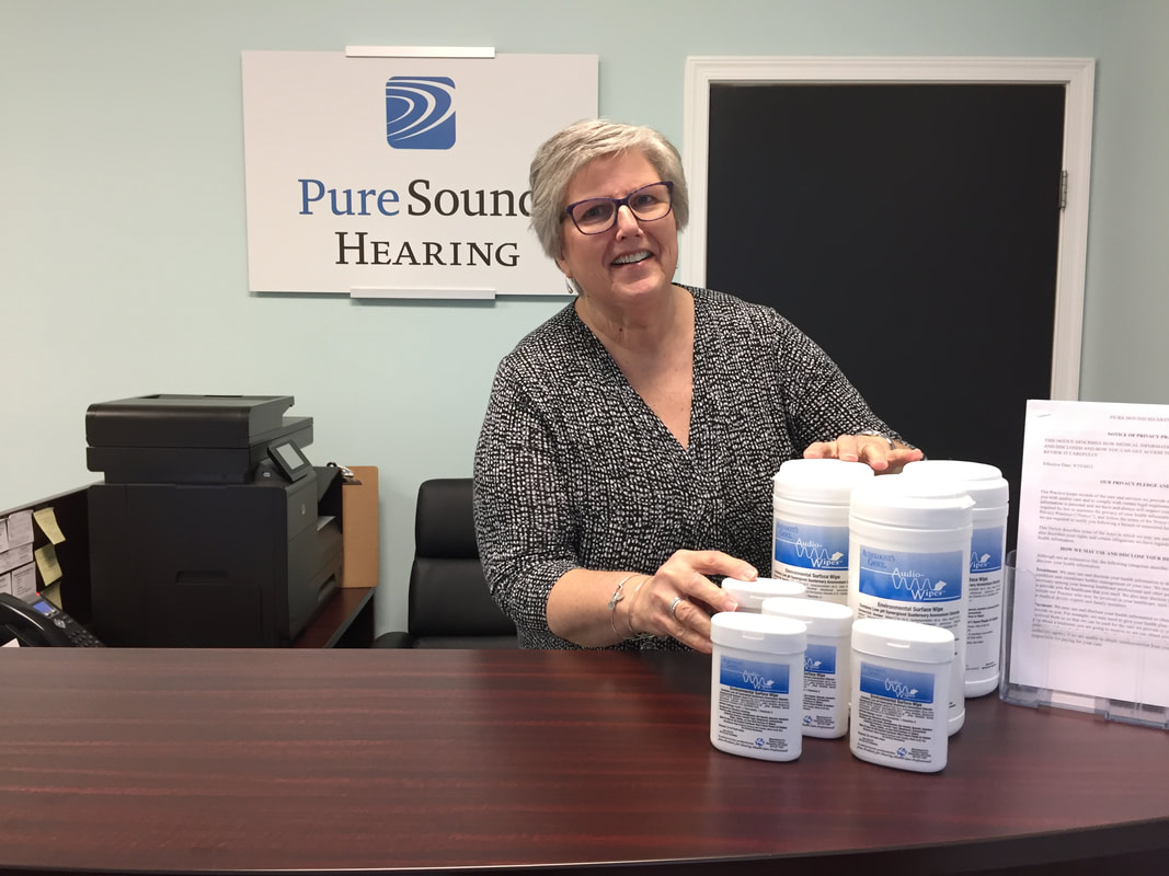 woman at lititz hearing aid office organizes and displays audio wipes for hearing aids at front desk