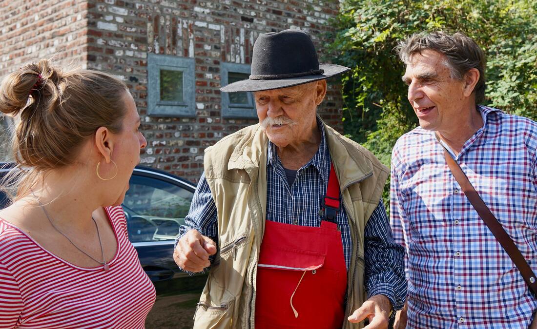 woman in red shirt and old man with plaid shirt brown jacket and hat and man with plaid shirt and bag and hearing loss talk in lancaster pennsylvania
