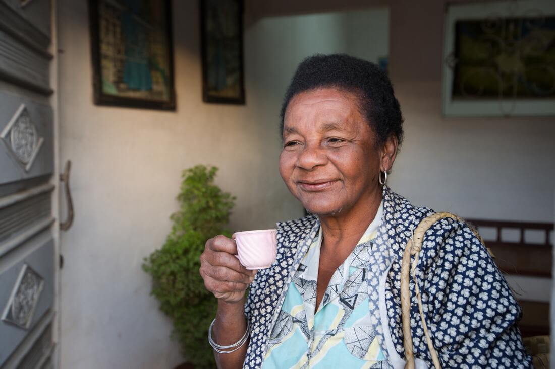 woman holding teacup wears hearing aids to slow dementia and alzheimers