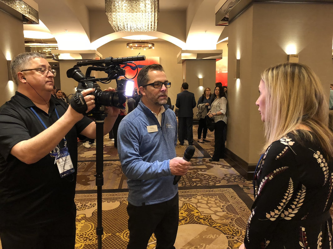 woman interviewed by reporter at hearing aid convention