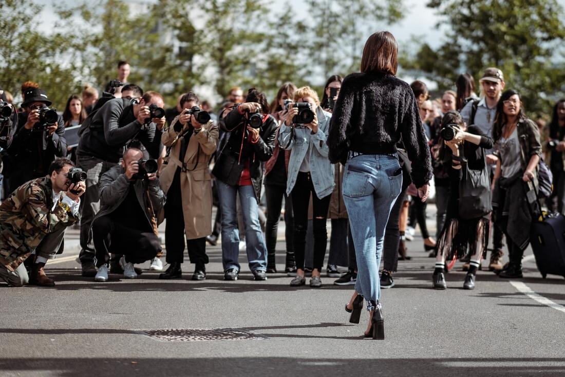 woman with hearing loss stands in front of paparazzi