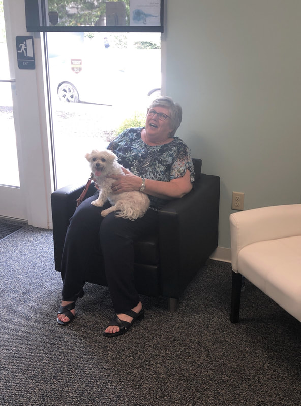 woman with small white dog in lancaster county hearing aid store