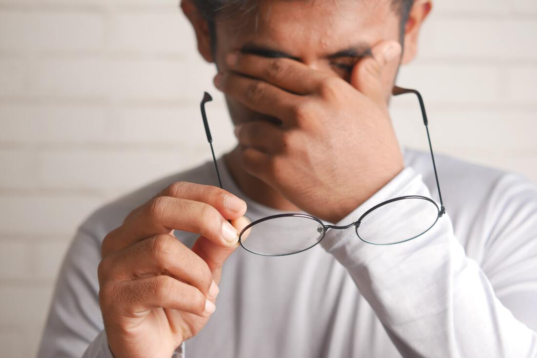 yogendra-singh-pRteNnOnJCc-unsplash-holds-eyeglasses-while-frustrated-with-tinnitus