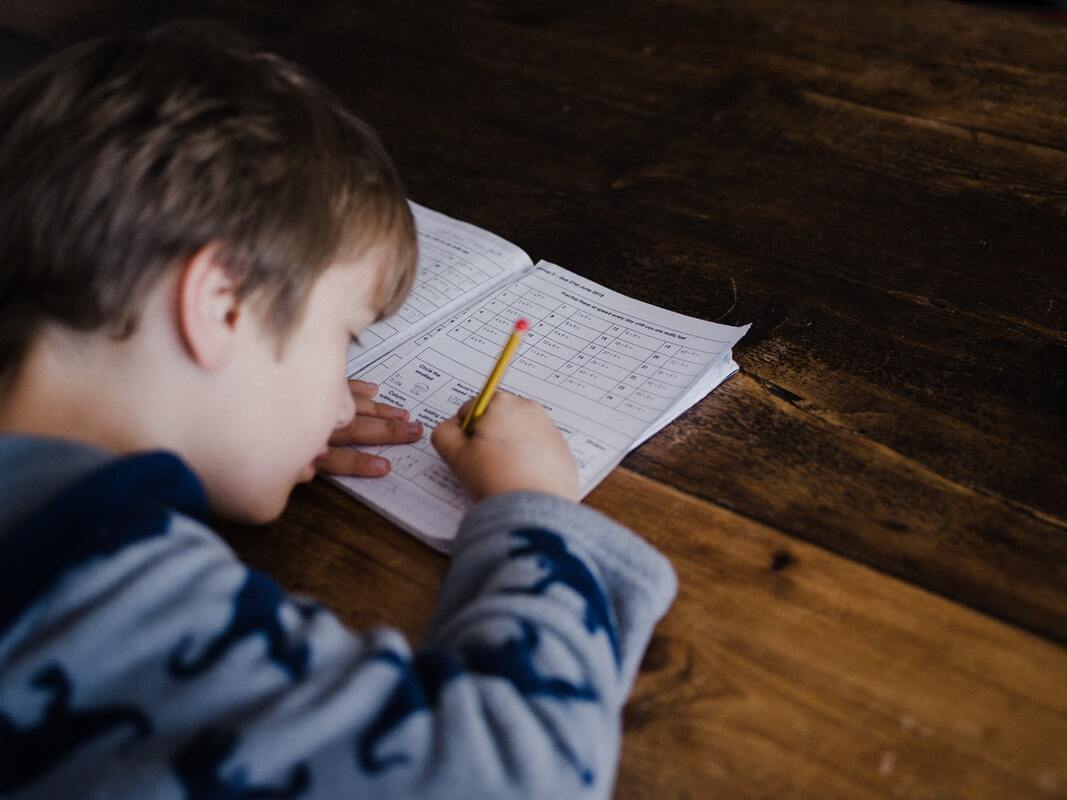 young boy with hearing loss writes on test